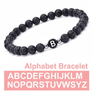 Custom 6mm black volcanic stone bracelet with a white letter B charm and silver spacers