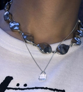 Detail of layered 925 sterling silver necklaces with irregular links and clear crystal