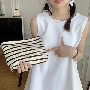 Large capacity striped cosmetic bag with black and white horizontal pattern in hand