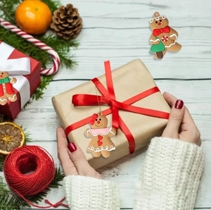 Christmas gingerbread man ornaments in a gift box with festive pine and orange decor