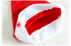 Detail of red Christmas felt hat featuring a small laser-cut snowflake on white soft trim