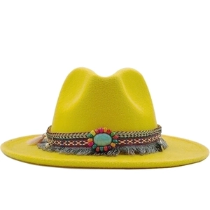 Detail van gele wollen hoed met turquoise edelsteen en bohemien band met franjes