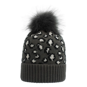 Close-up of leopard pattern knit hat with a large fluffy faux fur pompom on top