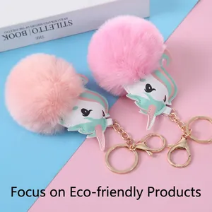 Pink faux fur unicorn keychain with gold lobster clasp shown on a pastel background