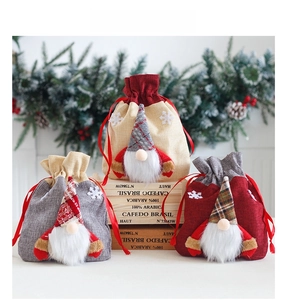 Christmas burlap gnome drawstring gift bags in beige, grey, and red with 3D gnome details