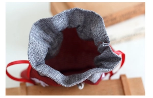 Detail of red and grey burlap Christmas gift bag with satin drawstring closure