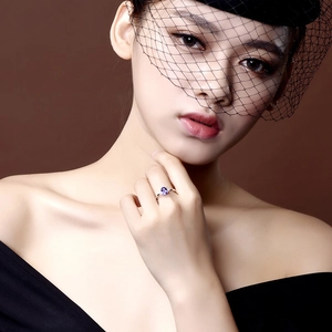 Elegant four-prong oval blue sapphire ring on model with high-quality silver band