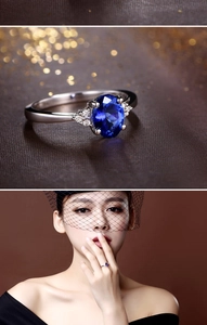 Close-up of royal blue oval gemstone ring with side accents shown on model
