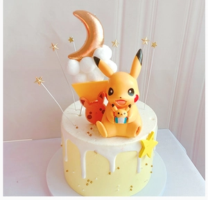 Close-up of yellow Pikachu cake topper figurine on a yellow drip cake with gold stars