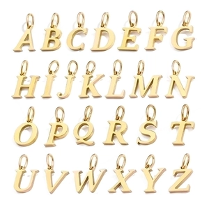 Flat lay of 26 gold alphabet pendants A-Z for DIY jewelry making on white background