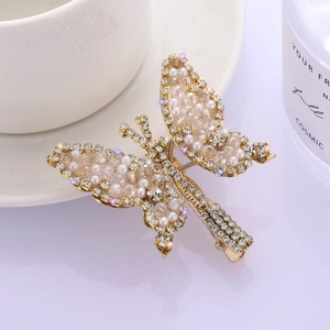Elegant gold butterfly hair clip with white pearls and sparkling crystals on white background