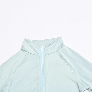 Detail of light blue long sleeve top featuring a zip-up half-high collar and soft fabric