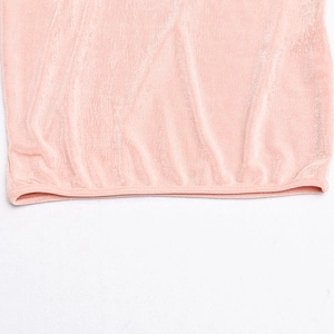 Gros plan sur la texture velours rose et les coutures de cet ensemble deux pièces