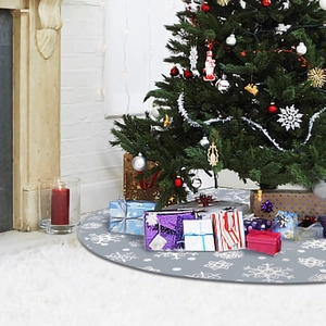 Gray Christmas tree skirt with white snowflake patterns in an indoor holiday setting