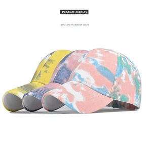 Detailansicht von drei Tie-Dye-Baumwoll-Baseballkappen mit leuchtenden Farben und Stoffstruktur