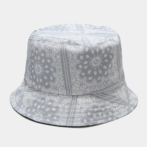 Detail of light grey paisley pattern texture on the fabric of a reversible bucket hat