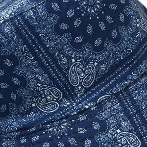 Detailed close-up of dark blue paisley bucket hat fabric with white floral print and stitching
