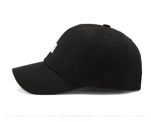 Detail of white letter embroidery and stitching on a black cotton baseball cap