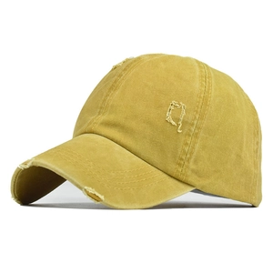 Detail of vintage washed cotton baseball cap in ginger yellow with distressed frayed edges
