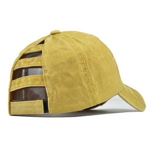 Detail view of washed yellow ponytail baseball cap with elastic straps and velcro closure
