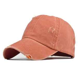 Detail of coral-washed cotton ponytail baseball cap with distressed frayed edges and PP logo