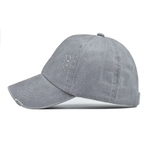 Detail view of washed grey cotton ponytail baseball cap with distressed frayed brim