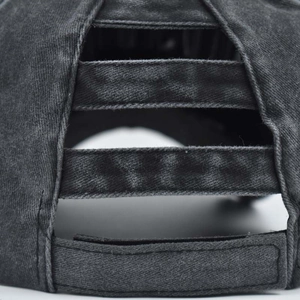 Macro detail of elastic criss-cross ponytail hole on vintage washed denim baseball cap