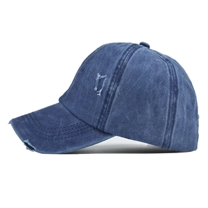 Close-up of distressed washed blue denim baseball cap with vintage frayed brim detail