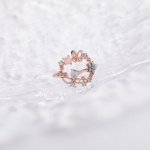 Close-up of rose gold flower ring with pink cat eye stone and hollow butterfly detail