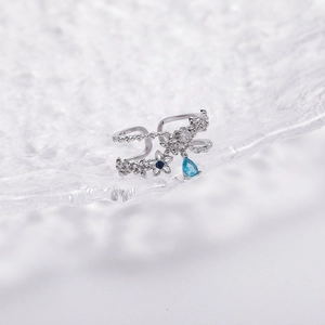 Detailed shot of silver adjustable flower ring with sparkling zircon and blue drop gemstone