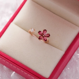 Macro detail of rose gold flower ring with pink crystals and zircon in a red gift box