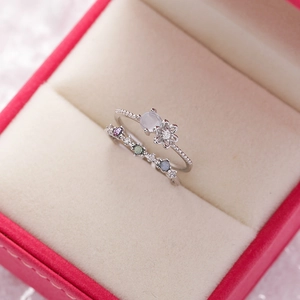 Close-up of silver stackable flower rings with purple zircon in a velvet jewelry box