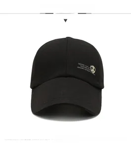 Detail of black baseball cap featuring a golden shield emblem and white sports printing