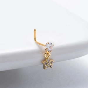 Macro shot of gold nose stud with sparkling star pendant and clear zircon stone