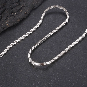 Silver titanium steel prism link chain necklace displayed on dark textured stone surface