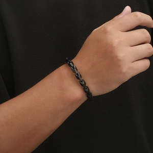 Detail of a sleek black geometric link chain necklace with high gloss metallic finish