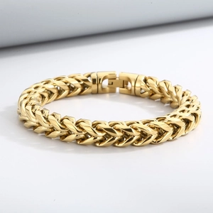 Macro view of golden wheat chain link bracelet with polished metal finish and sturdy clasp