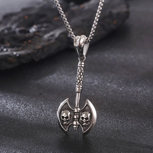 Macro view of stainless steel punk axe pendant featuring detailed dual skull engravings