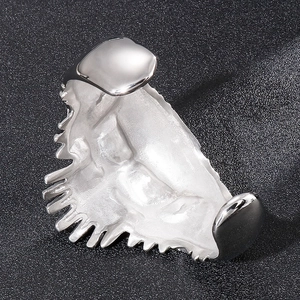 Macro detail of silver stainless steel cuff featuring unique skeletal tooth-like design