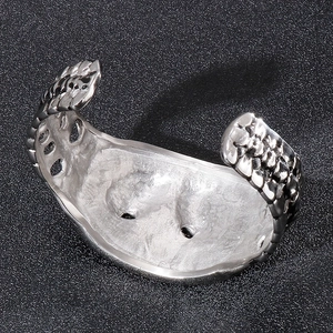 Detailed view of silver wide open cuff bracelet with hammered scale texture and metallic finish