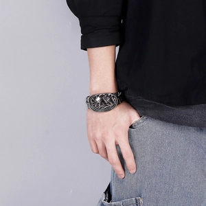 Detail of vintage silver skull engraved wide open cuff bracelet on male model wrist