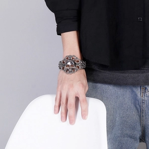 Detailed view of silver gothic cuff bracelet with skull relief and hollow scrollwork