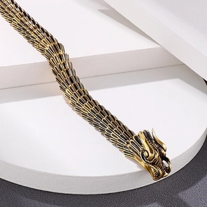 Detailed close-up of dragon head carving and scale patterns on retro steel bracelet