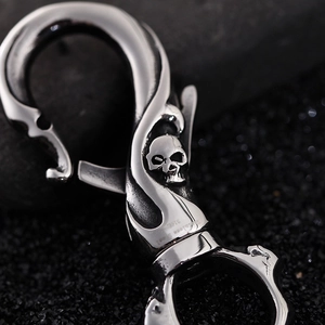 316L stainless steel skull keychain with swivel snap hook on dark textured background