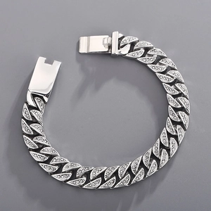 Macro shot of silver Cuban link bracelet with iced out pavé zircons and box clasp