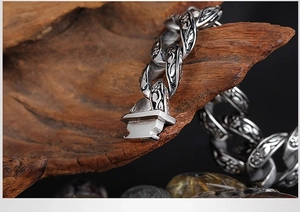 Detail of vintage carved Cuban link chain with black resin stone and silver metallic texture