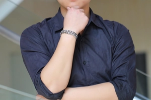 Close-up of vintage rose pattern Cuban chain bracelet on male model wrist