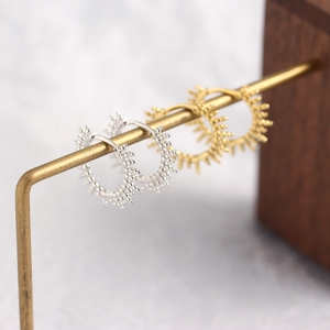 Close-up of S925 sterling silver beaded hoop earrings in gold and silver finishes