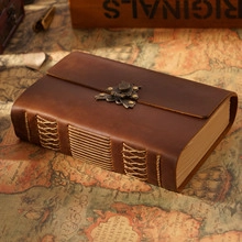 Detail of vintage brown leather journal with woven binding and antique metal clasp