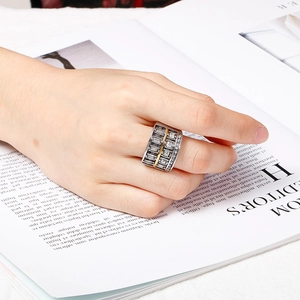 Wide 304 stainless steel ring with zircon stones on female hand over a magazine